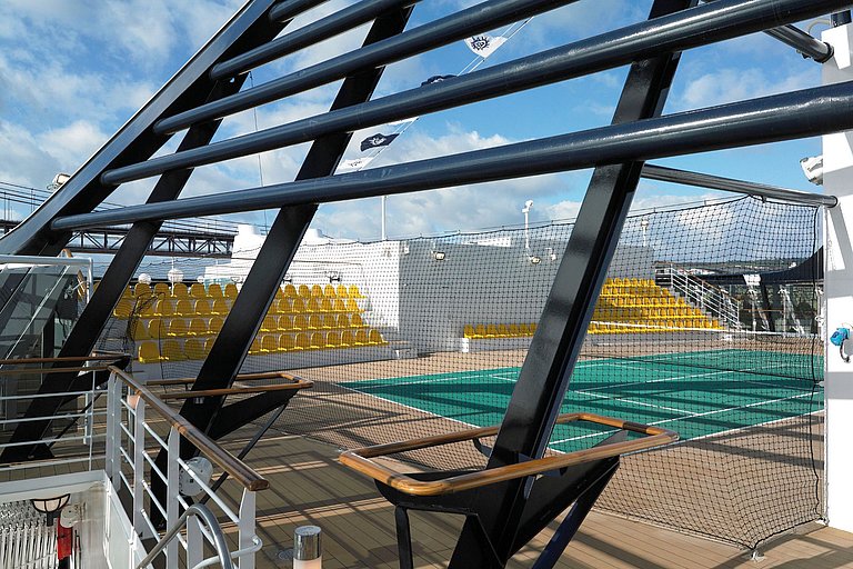 Blick auf einen Outdoor Tennisplatz mit Sitzgelegenheiten auf dem Schiffsdeck.