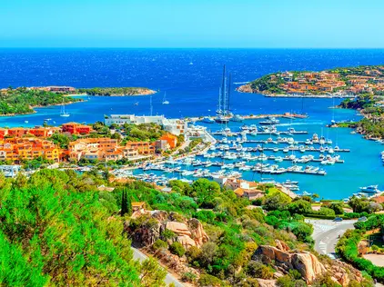 View of Porto Cervo, Italian seaside resort in northern Sardinia Felsige Küste auf Sardinien mit klarem Meer, grüner Macchia und kleinen Inseln.