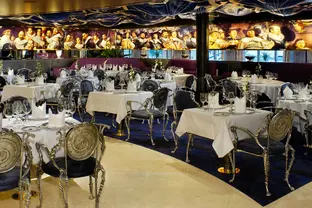Das Bild zeigt ein Schiffsrestaurant mit moderner Architektur und metallenen Stühlen.