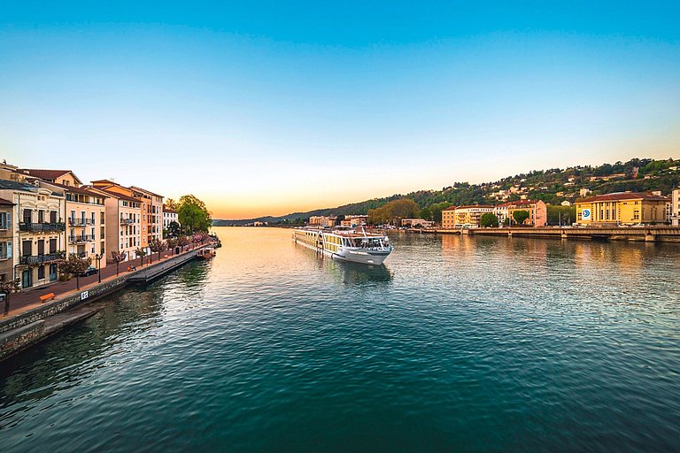 Breiter Kanal mit historischen Häusern am Ufer und warmem Licht der Abenddämmerung.