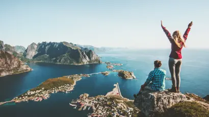 Couple family traveling together on cliff edge in Norway man and Wanderer auf Gipfel über Lofoten-Inseln, Fjorden und Bergen bei klarem Himmel.