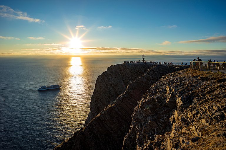 Mittagssonne über dem Meer am Nordkap mit felsiger Küste und weitem Horizont.