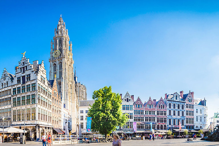 Blick auf moderne Skyline mit Wolkenkratzern und Palmen unter blauem Himmel.