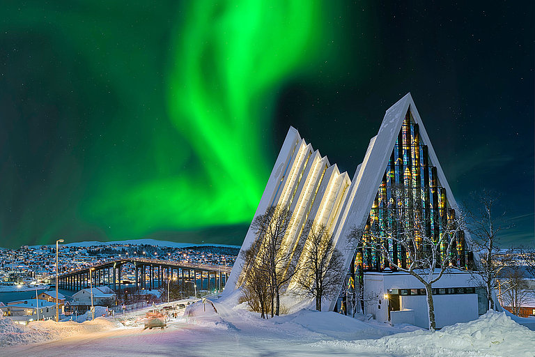 Nordlicht über Eismeerkathedrale Eismeerkathedrale in Tromsø mit grünem Nordlicht über verschneiter Winterlandschaft.
