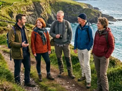 Reisegruppe in Irland vor grüner Landschaft mit Küste und weitem Panoramablick.