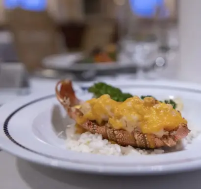 Nahaufnahme auf einen Teller mit Risotto und Fisch, in einem Restaurant.