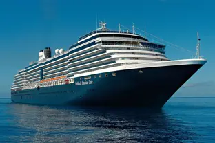 Ein Kreuzfahrtschiff auf dem blauen Meerwasser unter wolkenlosem Himmel.