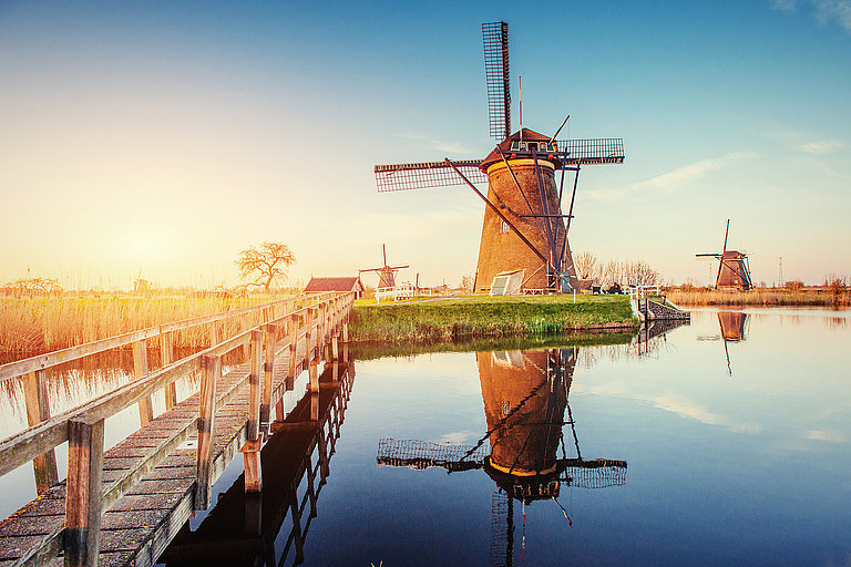 Windmühle in Rotterdam am Wasser bei Sonnenuntergang