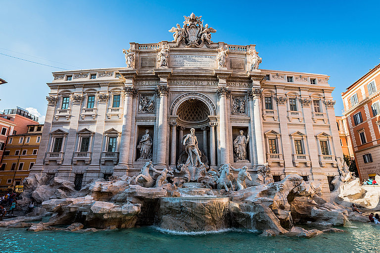 Trevi Brunnen in Rom mit barocker Fassade, Skulpturen und türkisblauem Wasser.