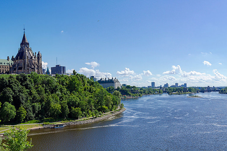 Panoramablick auf Ottawa mit Fluss, Parlament und grünen Ufern in Kanada.