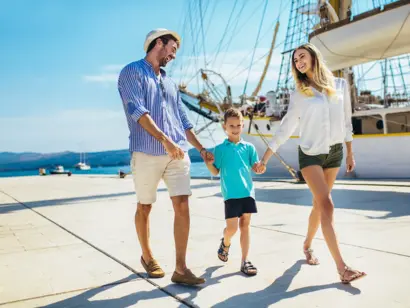 Familie am Hafen Ein glückliches Familienbild zeigt einen Mann, eine Frau und ein Kind auf dem Steg.