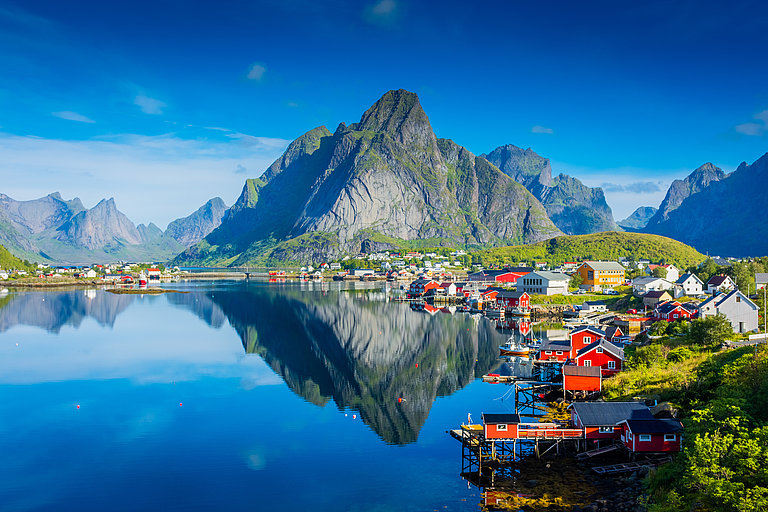 Reine auf den Lofoten in Norwegen ist ein malerisches Fischerdorf, das für seine beeindruckende Landschaft und atemberaubende Naturkulisse bekannt ist. Eingebettet zwischen dramatischen Berggipfeln und dem kristallklaren Wasser des Reinefjords, bietet Reine eine spektakuläre Aussicht auf die zerklüftete Küstenlinie der Lofoten-Inseln. 